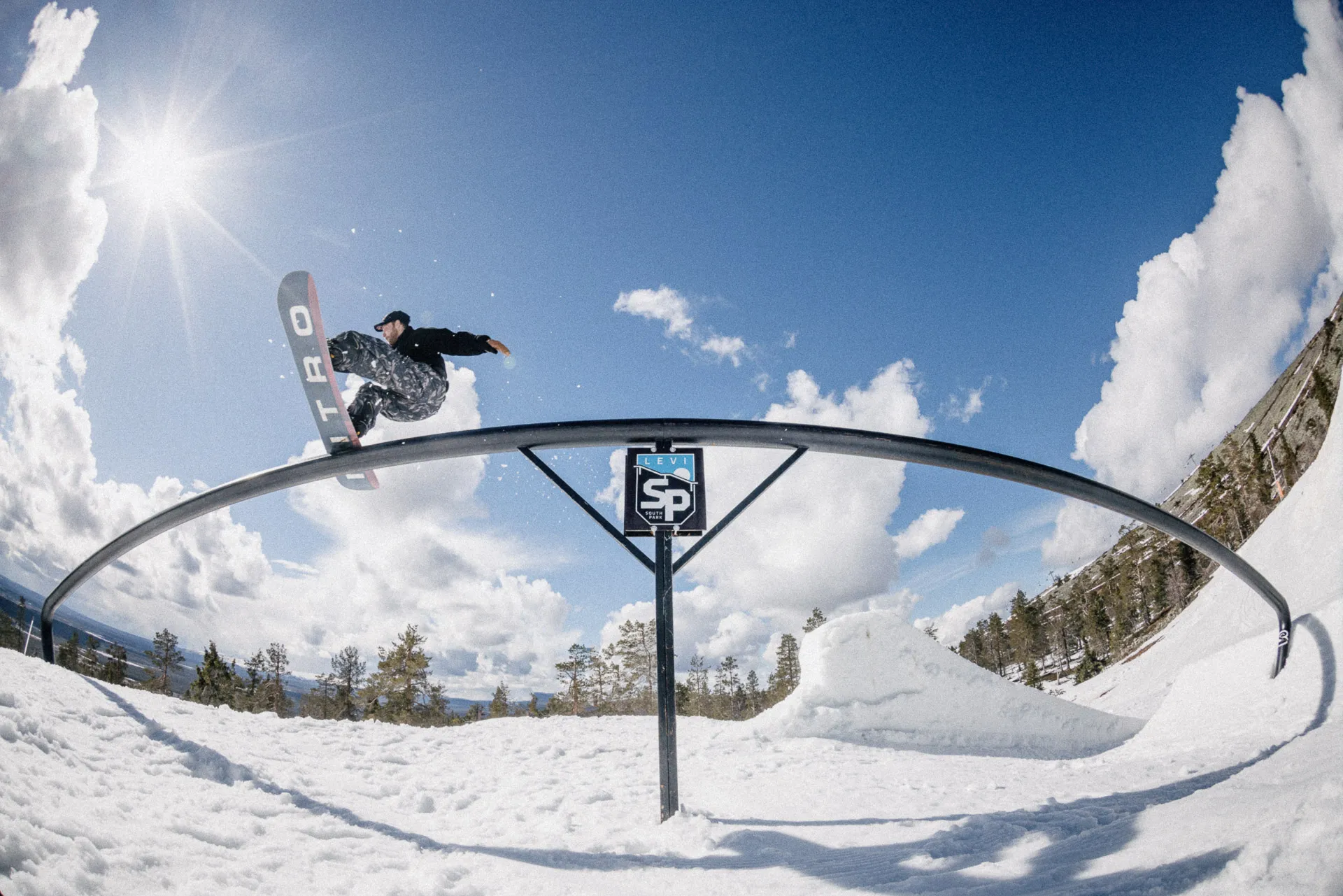 Snowboarder su un rail ad arco nel park di Levi, in Finlandia