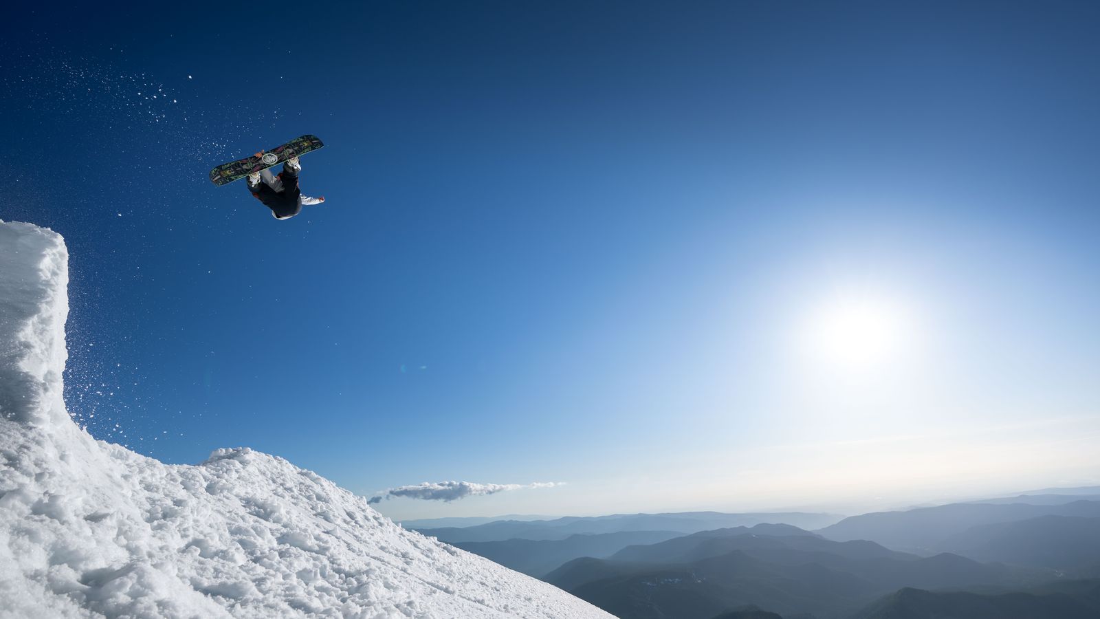 Snowboarder in salto sopra le montagne